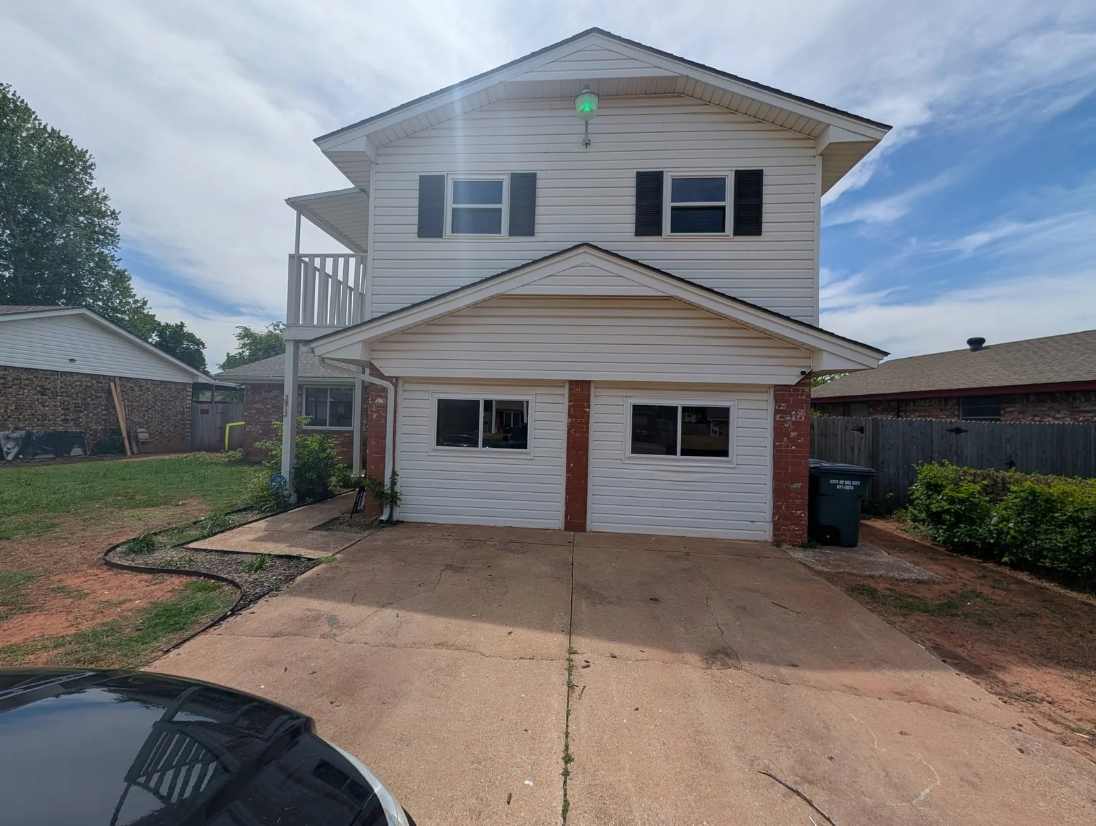 New double-hung windows installed on two-story home with brick and vinyl siding