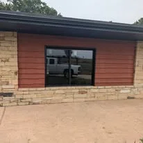 Black-framed double-pane window on red siding and brick exterior