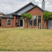 Brick home with newly installed replacement windows and black trim
